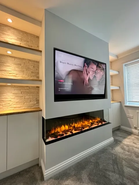 Modern living room featuring a built-in media wall with a large flat-screen TV displaying